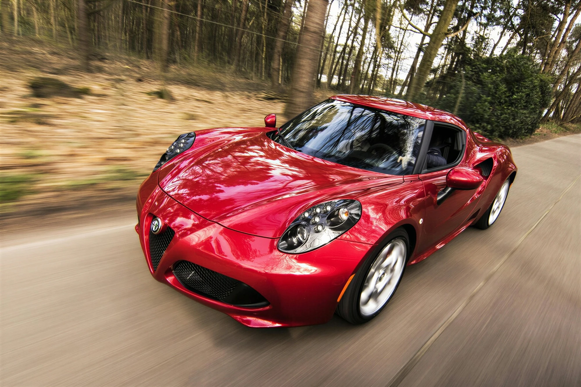 High-resolution of a red sports car driving fast on a forest road